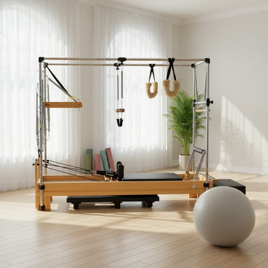 Maple wood Atro Pilates Cadillac reformer machine with tower and accessories in bright studio