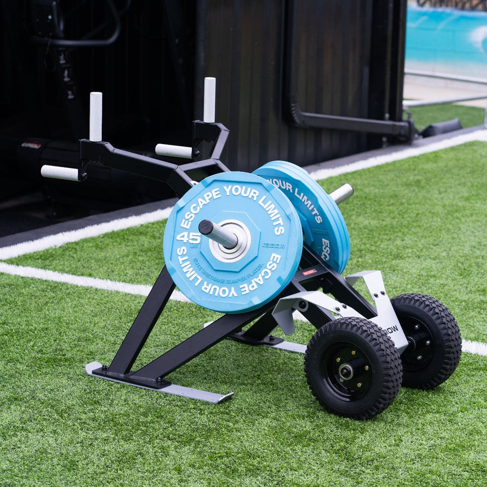 Escape Fitness Barrow Sled black loaded carry and sled push fitness equipment with blue weight plates on grass