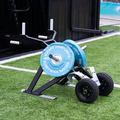 Escape Fitness Barrow Sled black loaded carry and sled push fitness equipment with blue weight plates on grass