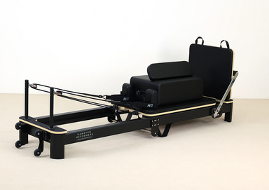 Origin Aluminium Folding Pilates Reformer with black padded carriage and adjustable resistance springs for home and studio use