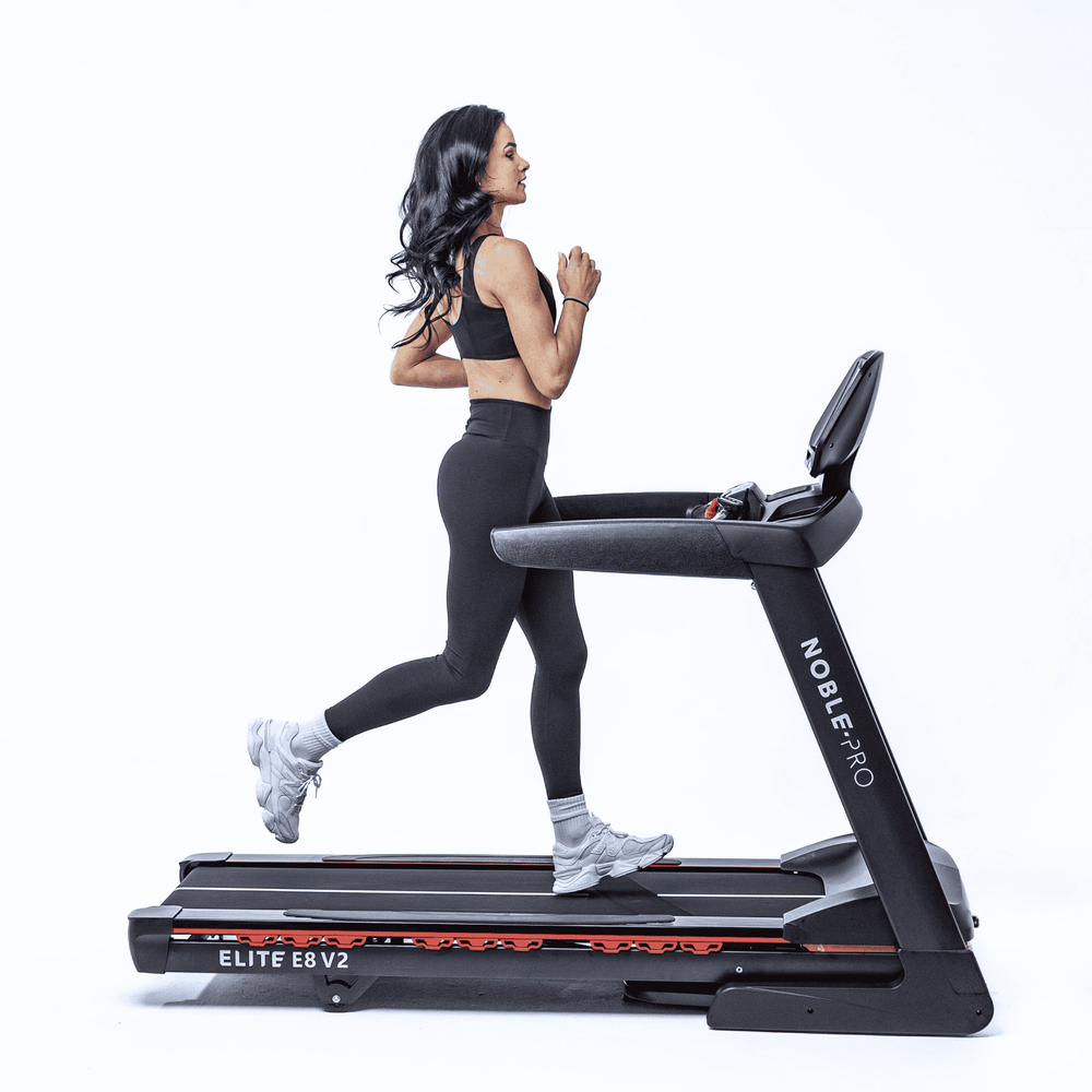 Woman running on NoblePro Elite E8s foldable treadmill for home gym and studio 